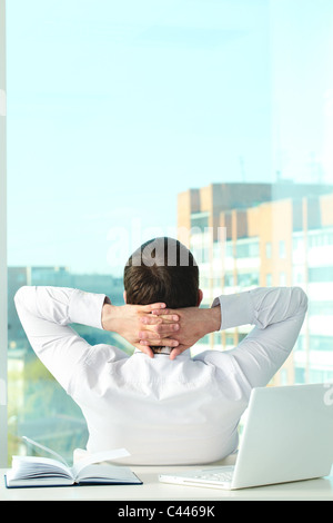 Image of young businessman sitting in office and having break Stock Photo