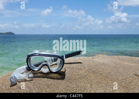 A diving mask and snorkel on a rock near the sea Stock Photo