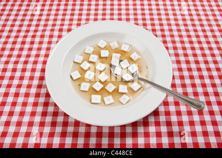 A bowl of soup with various computer keys floating in it Stock Photo