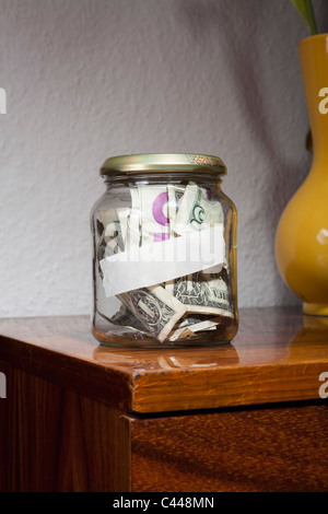 A jar full of US paper currency with a blank label on it Stock Photo