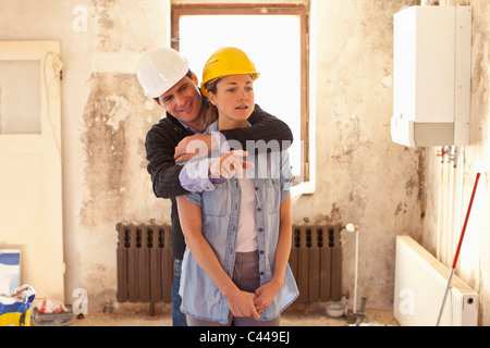 A couple standing in their house that's under renovation Stock Photo