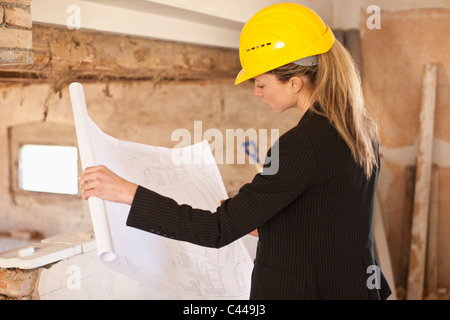 An architect reviewing blueprints at a building site Stock Photo