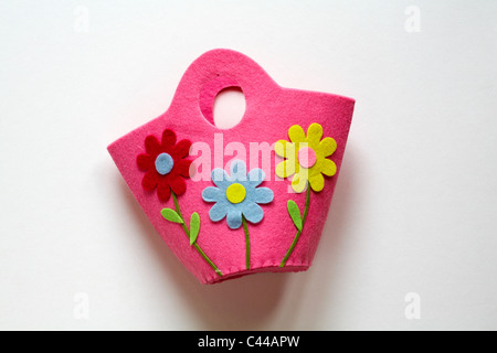childs pink felt bag with three brightly coloured daisies on it isolated on white background - ready for Easter Stock Photo