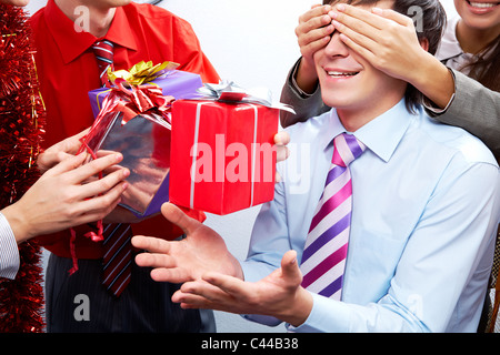 Image of man guessing what present he is going to receive from his colleagues Stock Photo