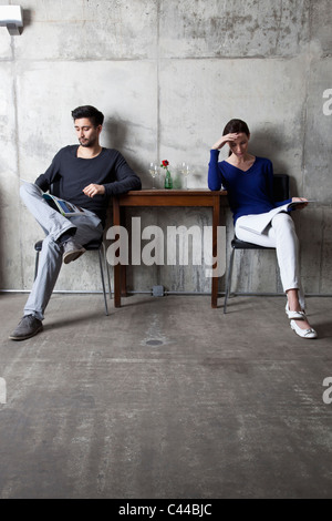 A couple ignoring each other while reading separate magazines Stock Photo