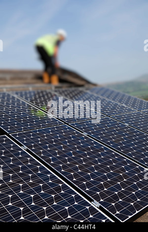 Fitting solar pv photovoltaic panels to house roof Llanfoist Wales UK Stock Photo