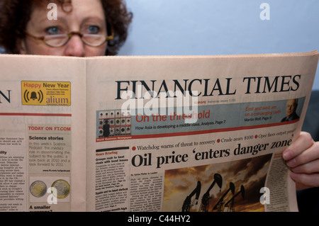 Woman reading a copy of the Financial Times European edition Stock Photo