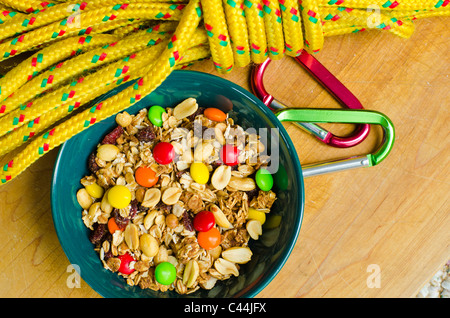 Trail mix or gorp often carried by hikers and climbers for a nutritious snack. Shown beside a climbing rope and carabiners Stock Photo