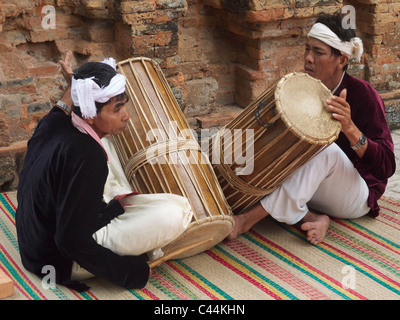 two Cham people in typical costume drumming by Po Nagar towers ruins near Nha Trang Vietnam Stock Photo