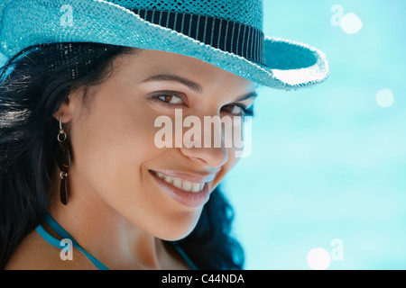 woman in straw hat relaxing near swimming pool. Copy space
