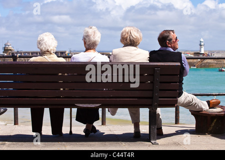 Group of pensioners on a bench at St Ives sea front in UK Stock Photo