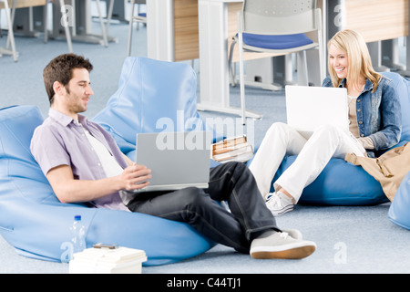 Young students at high-school relaxing pointing at laptop Stock Photo
