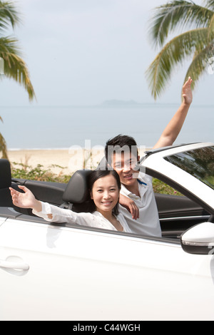 Happy Young Couple Posing in a Convertible Stock Photo