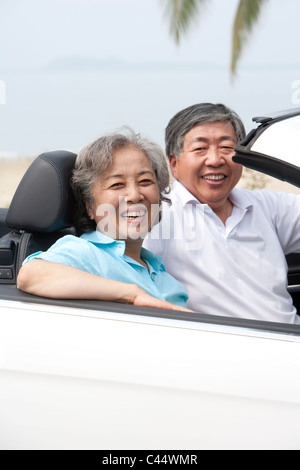 Happy Senior Couple Posing in a Convertible Stock Photo