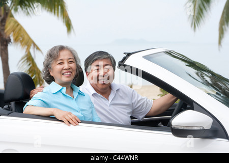 Happy Senior Couple Posing in a Convertible Stock Photo