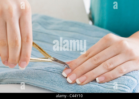 Woman using nail clippers Stock Photo