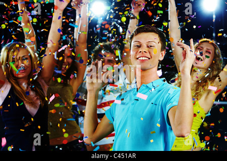 Portrait of stylish guy dancing on background of energetic friends Stock Photo