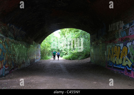 Couple walking under bridge Stock Photo