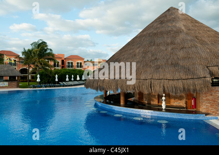 The pool bar at a resort on the Mayan Riviera in Mexico, Western Caribbean on a partly cloudy day. Underwater stools at the bar. Stock Photo