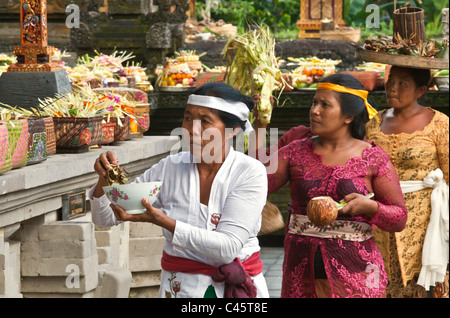 Women bring offerings to the PURA TIRTA EMPUL TEMPLE during the GALUNGAN FESTIVAL - TAMPAKSIRING, BALI, INDONESIA Stock Photo