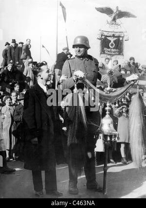 A soldier of the SS Bodyguard Regiment 'Adolf Hitler' is admired after the annexation of Austria, 1938 Stock Photo