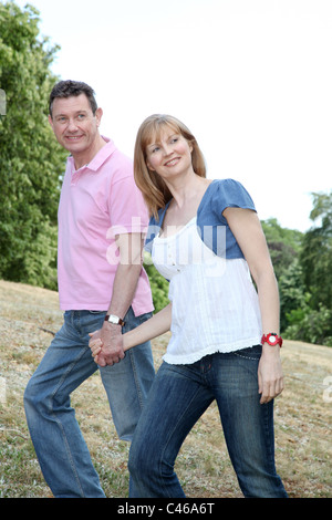 Couple walking in the countryside, smiling. Stock Photo