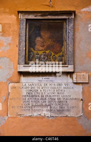 Religious icons and artifacts in a wall exhibit on a Rome street Stock Photo