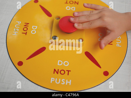 Child's hand pressing the "Do Not Push" Button! Stock Photo