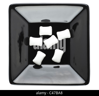 Chewing gum pieces in a square black ceramic dish Stock Photo