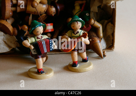 Two small wood carved figures of the Dregeno Seiffen eG like musicians displayed in front of a box with other manikins, Germany. Stock Photo