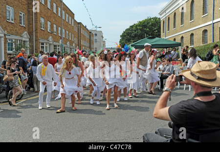 Man taking a photo of Samba dancers at this years Kemptown Carnival in Brighton summer UK Stock Photo
