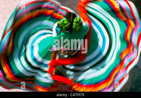 An overhead view shows off the colorful traditional dress of a twirling folkloric dancer who often entertains tourists in Mexico, North America. Stock Photo