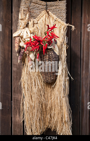 Shop hanging with red peppers, straw cape and colored corn cobs on main street, Tsumago, Kiso Valley, Nagano, Honshu, Japan. Stock Photo