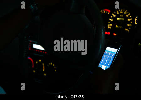Man using mobile phone in car, night shot Stock Photo