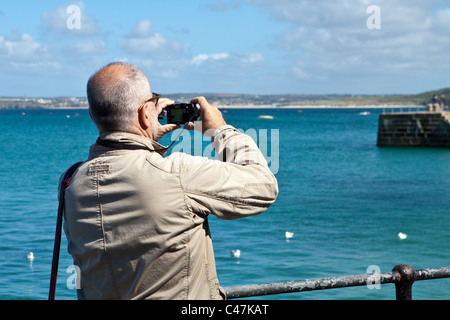 Tourist taking a photograph with a compact camera in St Ives, Cornwall Stock Photo