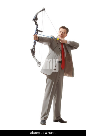 Portrait of courageous businessman holding crossbow and aiming at target Stock Photo