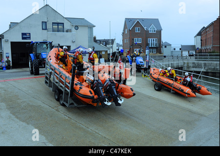 RNLI lifeboats being pulled by tractors and launched from the quayside at Littlehampton Harbour on the River Arun UK Stock Photo