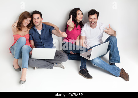 young group happy friends hoding aprooving laptops Stock Photo