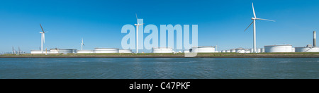 windmills between large white tanks for petrol and oil in the Rotterdam harbor Stock Photo