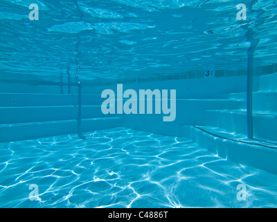 Underwater approach to stairs and seating in a clean suburban pool. Stock Photo