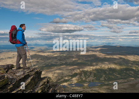 Wanderer auf einem Gipfel im Alvdal Vestfjell, in der Ferne der Berg Rendalssoelen, Rendalen, Hedmark, Norwegen Stock Photo