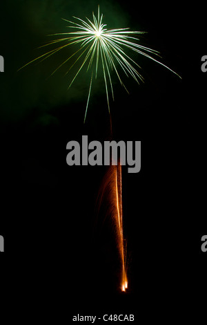 Firework explosion and trail in gold and green Stock Photo