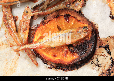 Spicy fried anchovies and slice of lemon - detail Stock Photo