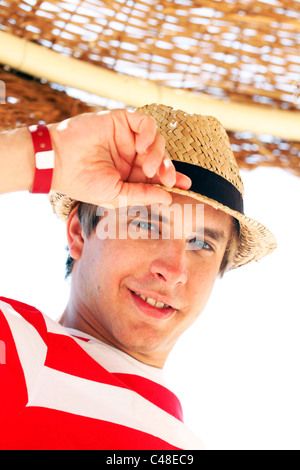 Model released portrait of a man on summer holiday wearing a straw hat Stock Photo