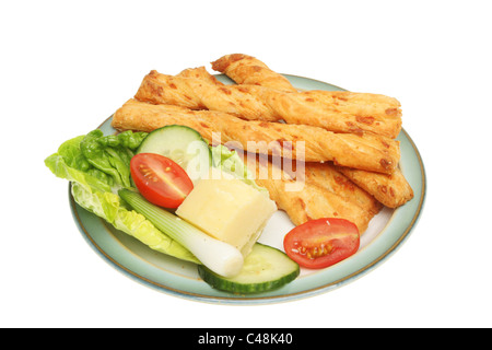 Cheese twists and salad garnish on a plate isolated against white Stock Photo
