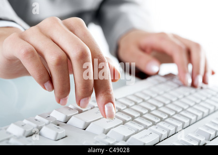 Macro image of human hand with forefinger going to press key on keyboard Stock Photo