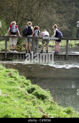 Young children playing Pooh Sticks on the River Dove, Wolfscote Dale, Peak District National Park, England, UK Stock Photo