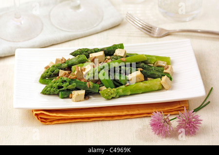 Asparagus with tofu and sunflower seeds. Recipe available. Stock Photo