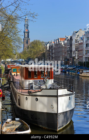 Houseboat on Prinsengracht with the tower of the Westerkerk (Westertoren) behind, Grachtengordel, Amsterdam, Netherlands Stock Photo