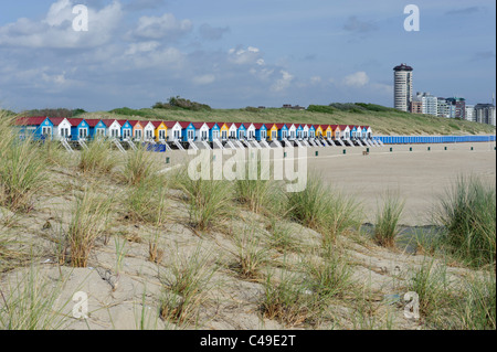 View from behind the sand dunes on colourful beach cabins near Vlissingen. Zeeland, Netherlands. Stock Photo